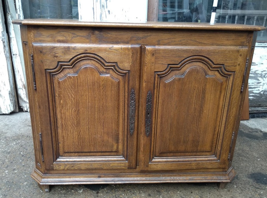 SMALL CANTED CORNER OAK SERVER WITH ARCHED DOORS