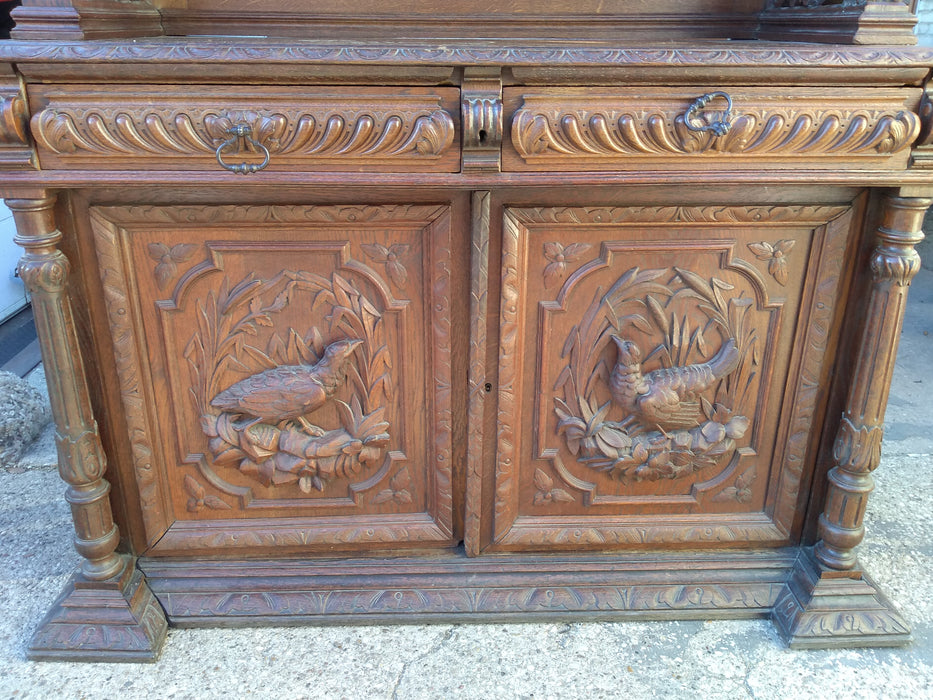 CARVED HUNTBOARD WITH LIONS, BIRDS AND BEVELED GLASS DOORS