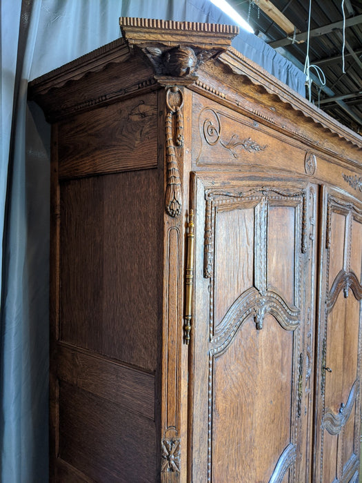 ORNATELY CARVED LOUIS XV OAK ARMOIRE WITH CHERUB HEADS