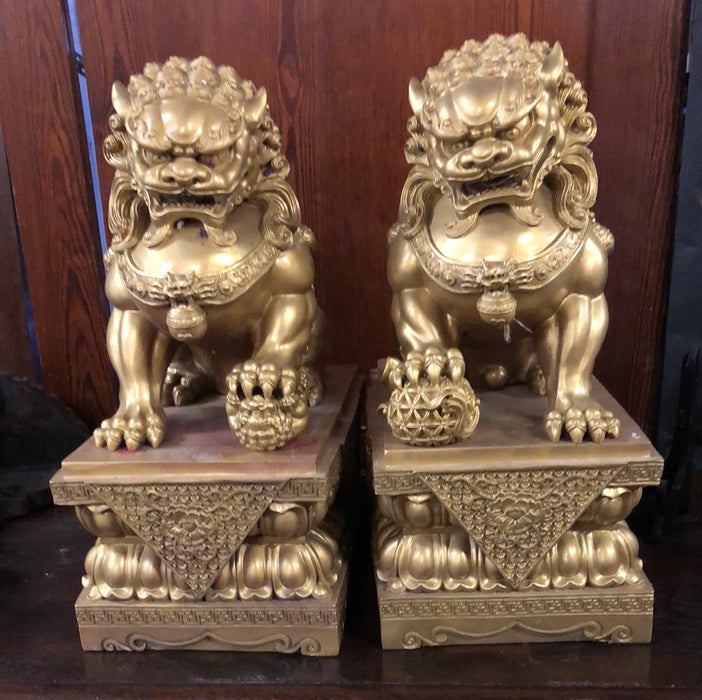 PAIR OF GILT FOO DOG SCULPTURES ON STANDS