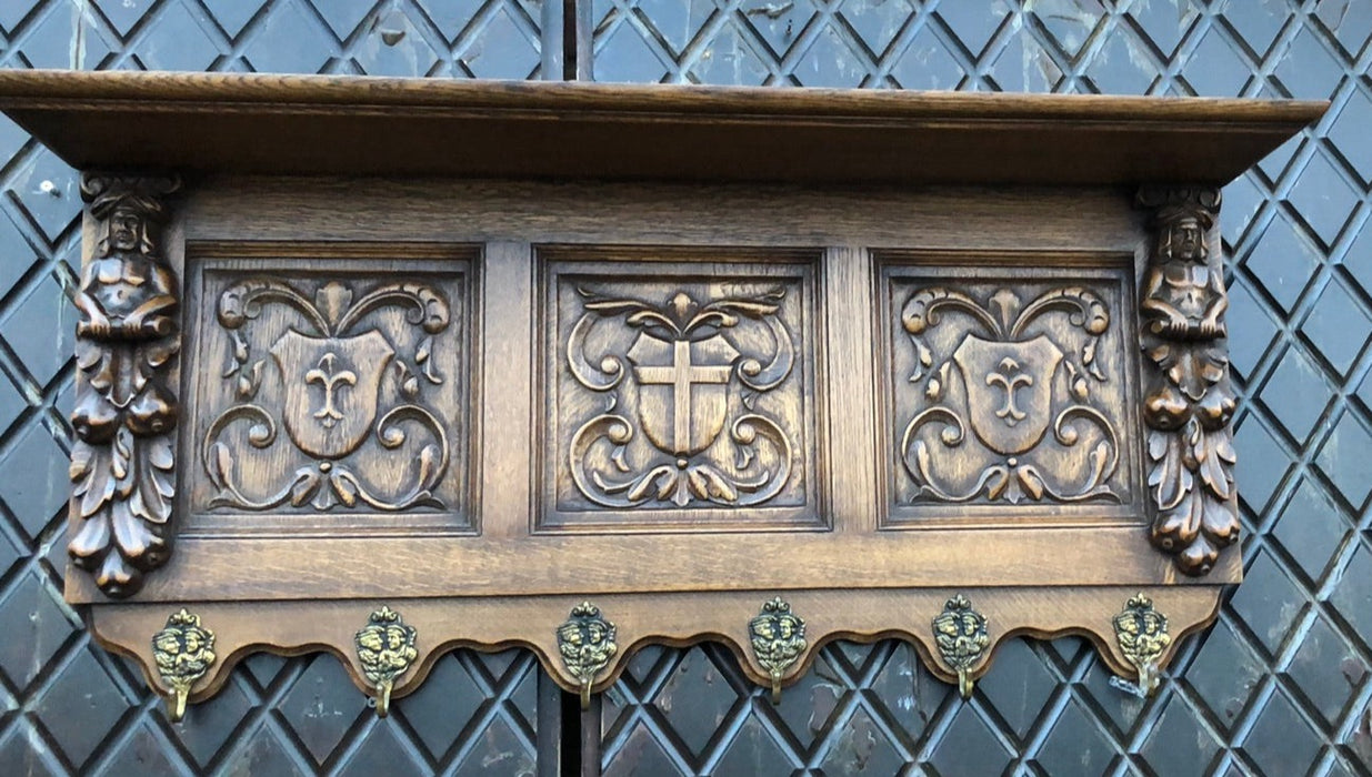 OAK CROSS AND FIGURAL CARVING WALL SHELF WITH HOOKS