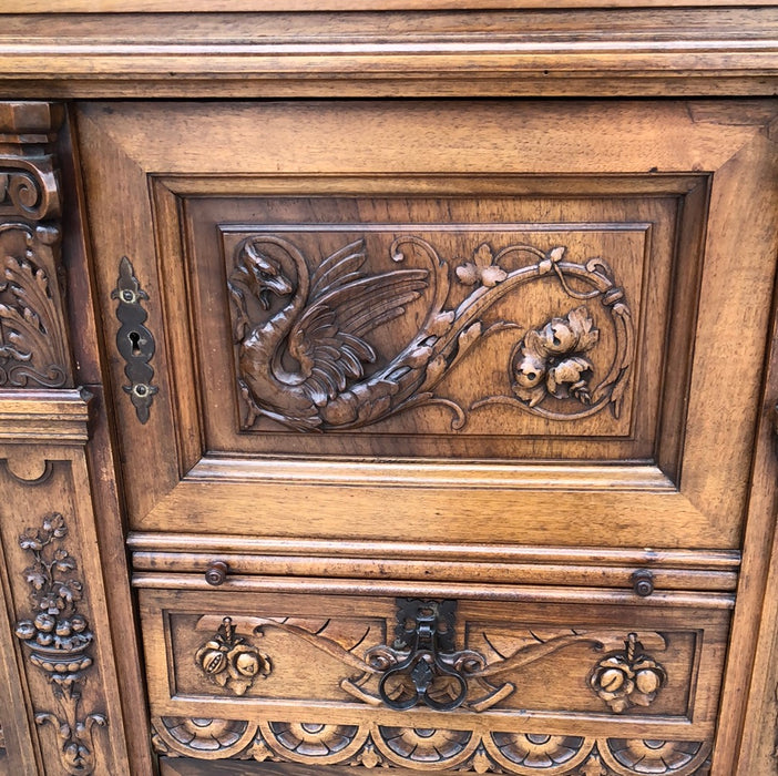 WALNUT GRIFFIN CARVED CABINET WITH CANTED ENDS