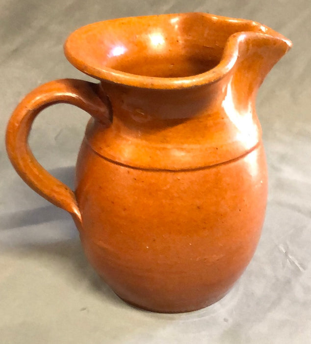 SMALL HAND THROWN ORANGE POTTERY PITCHER