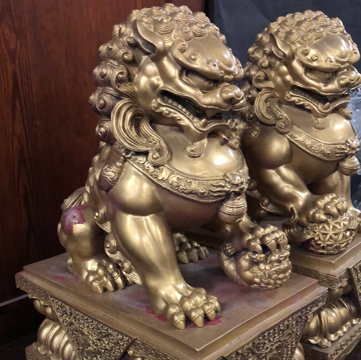 PAIR OF GILT FOO DOG SCULPTURES ON STANDS